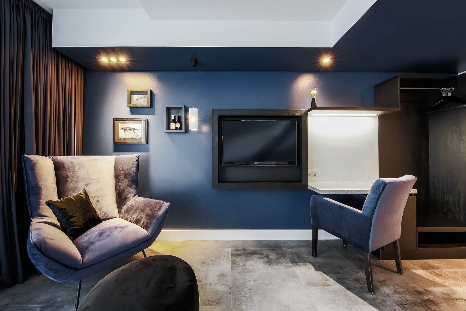 Blaues Gästezimmer mit Sessel als Teil des Markenauftritts von little BIG hotels.