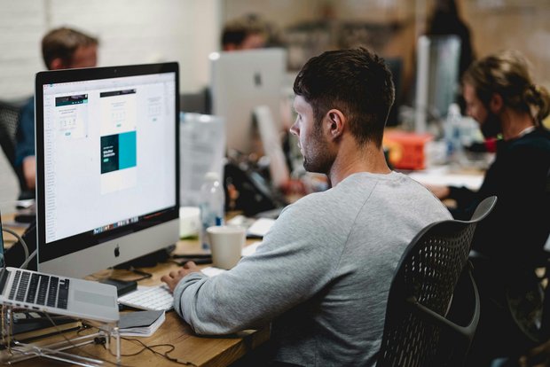 Employee working focused at a computer screen in an office