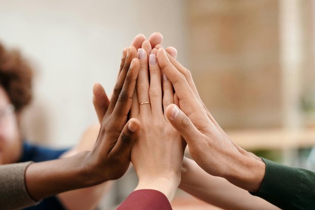 Diverse hands coming together for a high five as a sign of team spirit